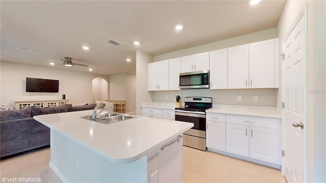 kitchen featuring a kitchen island with sink, stainless steel appliances, sink, ceiling fan, and white cabinets