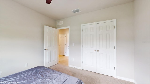 unfurnished bedroom featuring a closet, ceiling fan, and light carpet