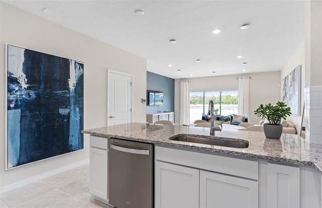 kitchen with white cabinetry, light tile patterned floors, dishwasher, sink, and light stone countertops