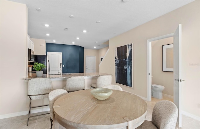 dining space with sink and light tile patterned flooring