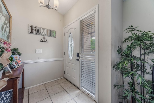 foyer with light tile patterned floors and a notable chandelier