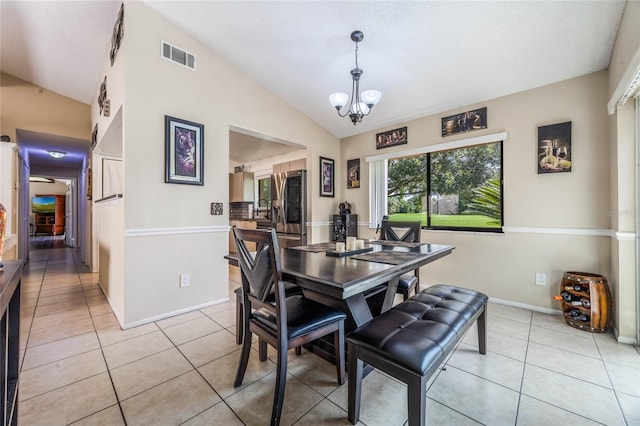 dining room with vaulted ceiling, an inviting chandelier, and light tile patterned floors