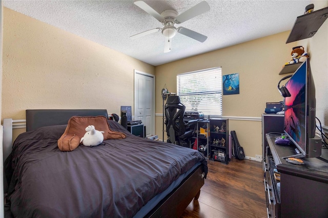 bedroom featuring a textured ceiling, ceiling fan, dark hardwood / wood-style floors, and a closet