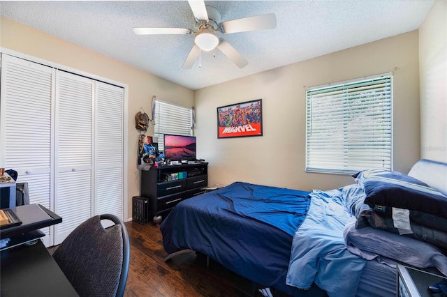 bedroom featuring a textured ceiling, dark wood-type flooring, ceiling fan, and a closet