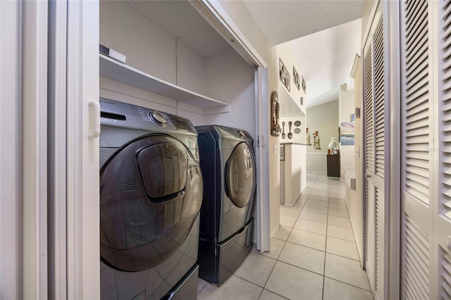 washroom featuring independent washer and dryer and light tile patterned flooring