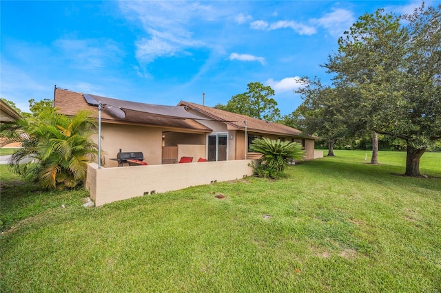 rear view of property featuring a yard