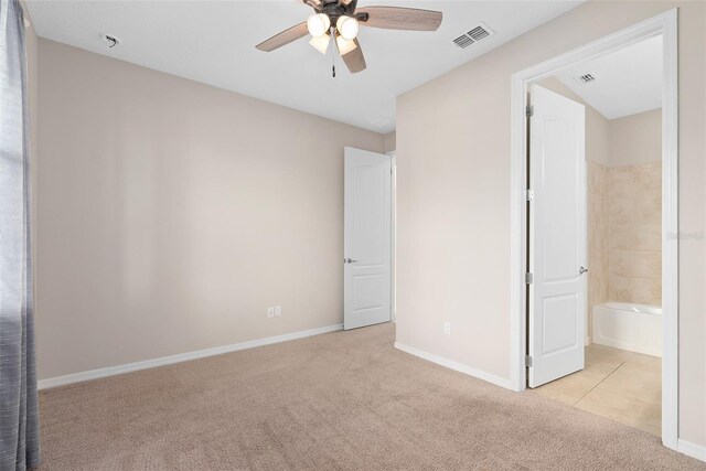 unfurnished bedroom featuring a ceiling fan, light carpet, visible vents, and baseboards