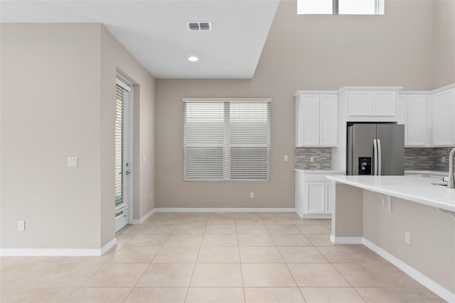 kitchen featuring white cabinets, visible vents, light countertops, and stainless steel fridge with ice dispenser