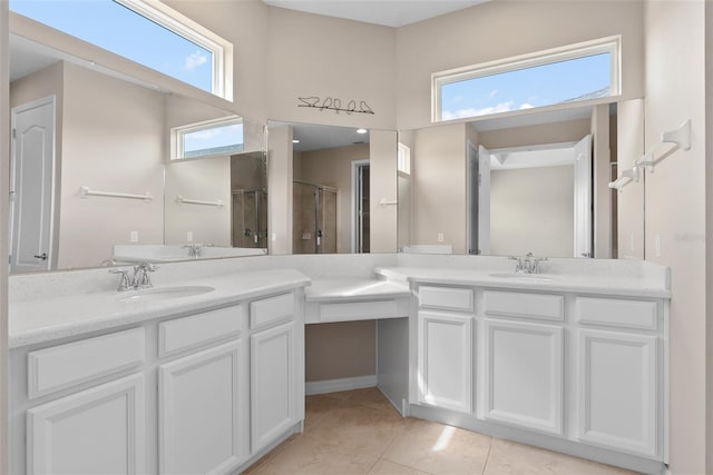 bathroom with a stall shower, two vanities, a sink, and tile patterned floors