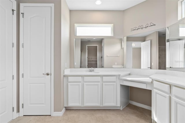 bathroom with a closet, vanity, and tile patterned floors