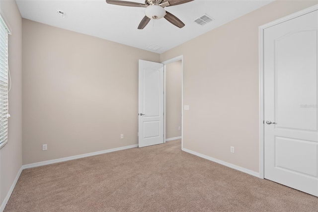 unfurnished room featuring light carpet, ceiling fan, visible vents, and baseboards