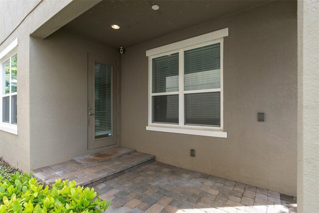 doorway to property featuring a patio and stucco siding