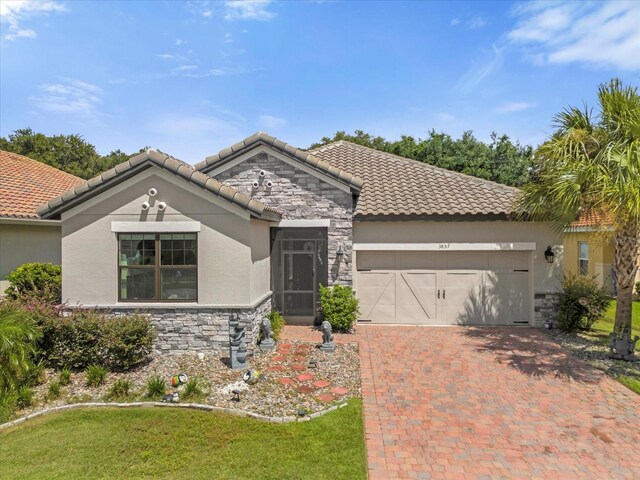 mediterranean / spanish house featuring a garage and a front lawn