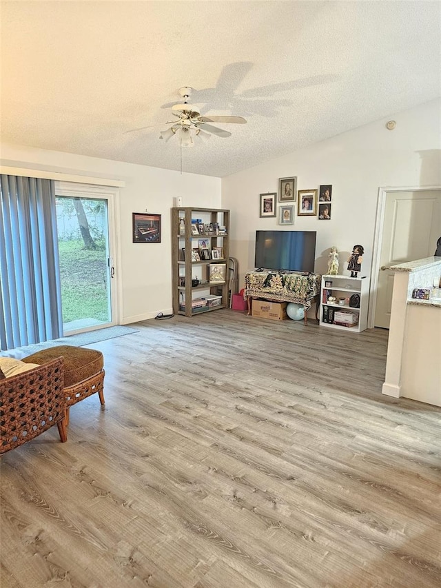 sitting room featuring a textured ceiling, ceiling fan, and light hardwood / wood-style floors