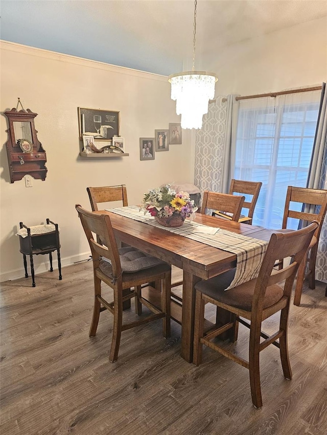 dining space with a chandelier, dark hardwood / wood-style flooring, and crown molding