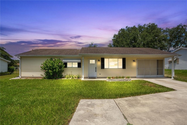 ranch-style home with a yard and a garage