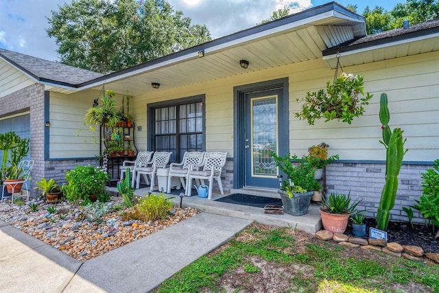 doorway to property featuring covered porch and a garage