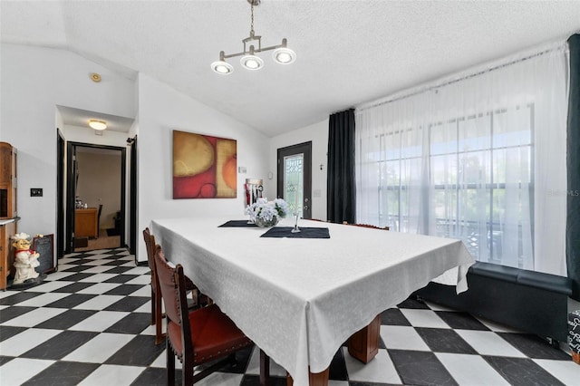 dining area with a textured ceiling and vaulted ceiling