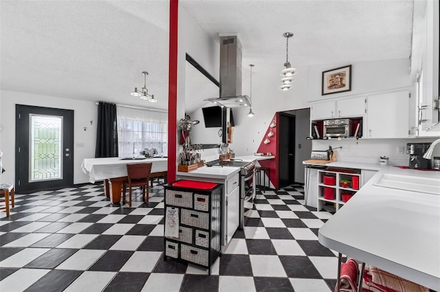 kitchen with sink, a textured ceiling, decorative light fixtures, white cabinetry, and range hood