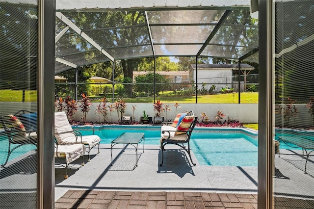 view of swimming pool with glass enclosure and a patio area