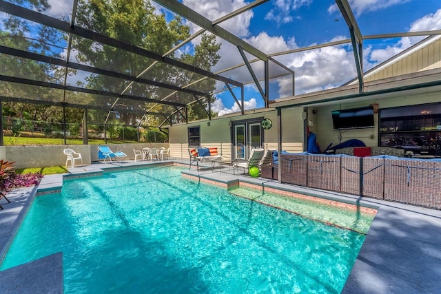 view of pool featuring glass enclosure and a patio area