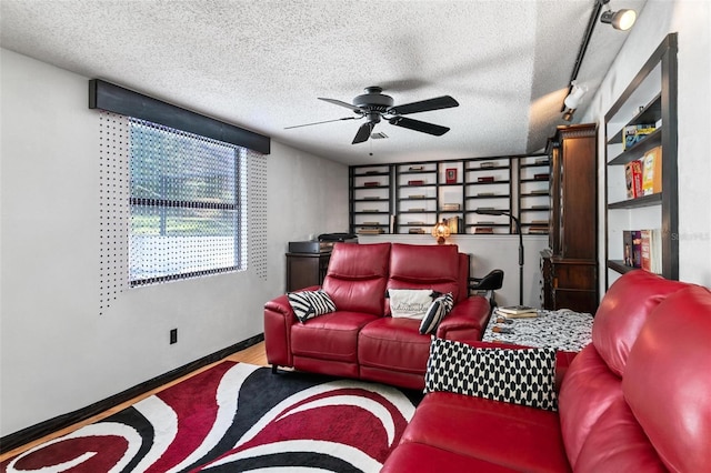 living room with ceiling fan, a textured ceiling, and track lighting