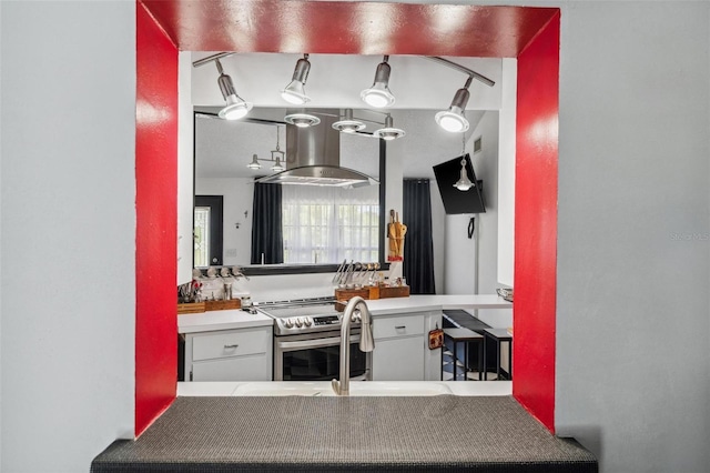 kitchen with island range hood and stainless steel range with electric cooktop