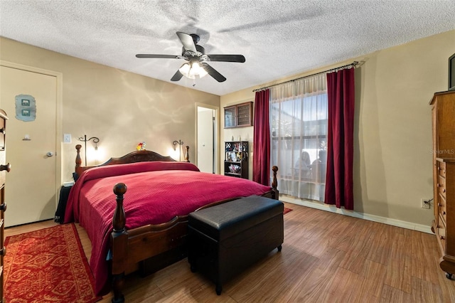 bedroom featuring wood-type flooring, a textured ceiling, and ceiling fan