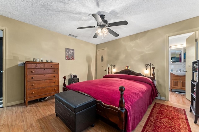 bedroom featuring hardwood / wood-style flooring, ceiling fan, connected bathroom, and a textured ceiling