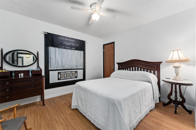 bedroom featuring a textured ceiling, light wood-type flooring, and ceiling fan