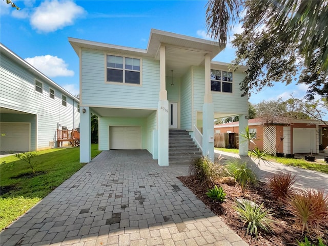 view of front facade featuring a front lawn, decorative driveway, and an attached garage