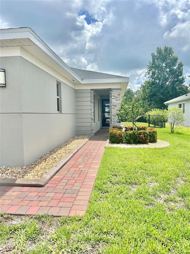 view of exterior entry with a lawn