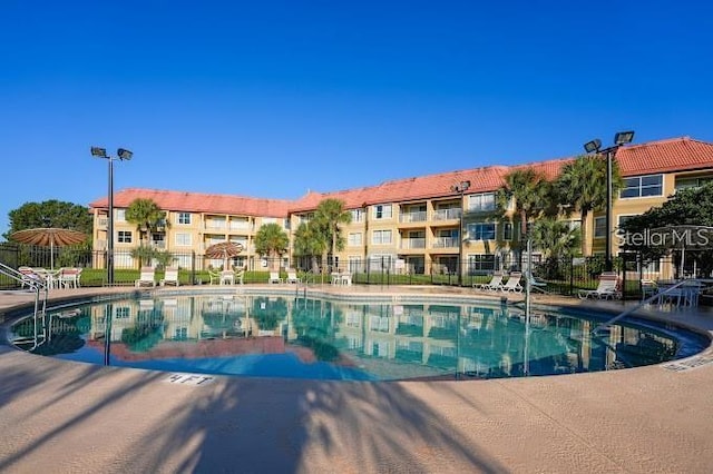 view of swimming pool with fence and a patio