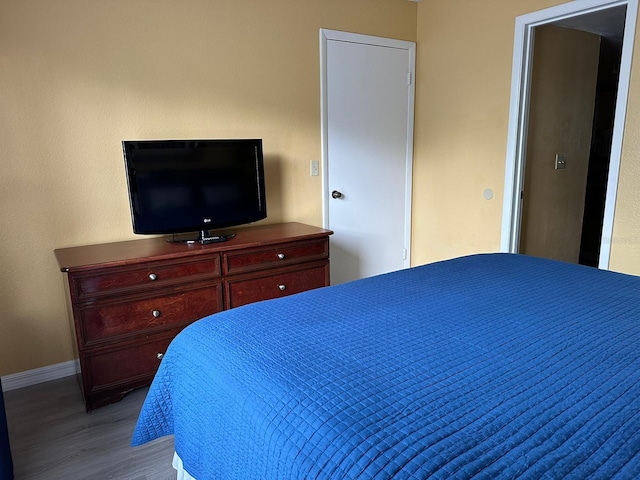 bedroom featuring baseboards and wood finished floors