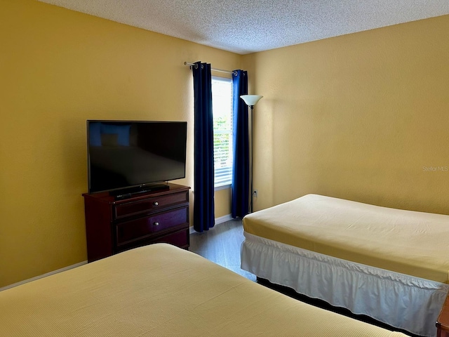 bedroom featuring a textured ceiling and wood finished floors