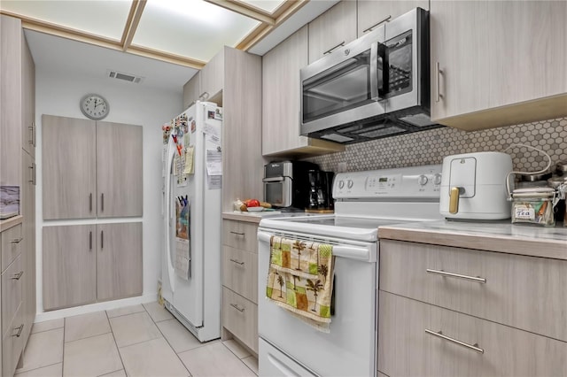 kitchen with backsplash, light brown cabinets, white appliances, and light tile patterned flooring