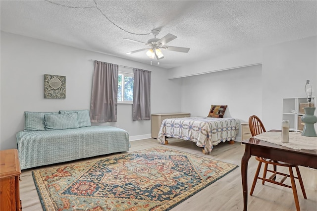 bedroom featuring light wood-type flooring, ceiling fan, and a textured ceiling