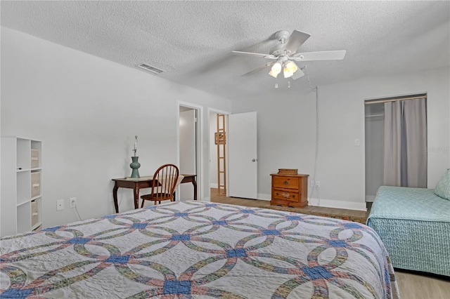 bedroom featuring a closet, ceiling fan, hardwood / wood-style flooring, and a textured ceiling