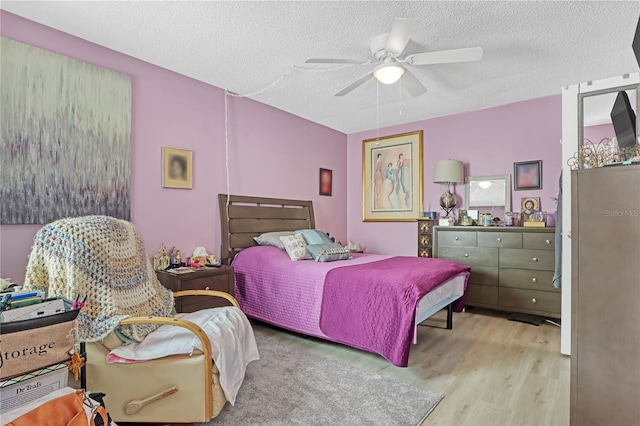 bedroom featuring a textured ceiling, light hardwood / wood-style flooring, and ceiling fan