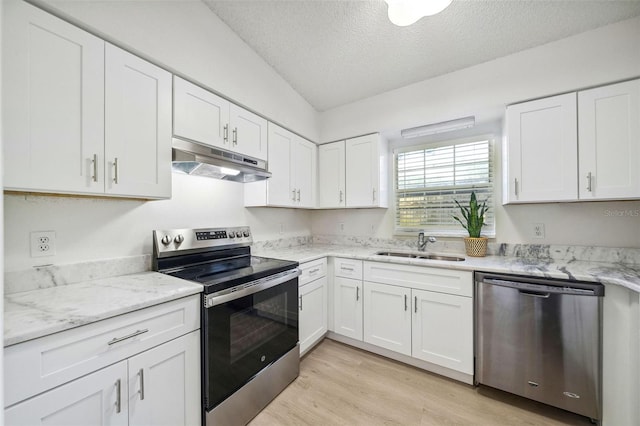 kitchen with white cabinets, sink, light hardwood / wood-style flooring, a textured ceiling, and appliances with stainless steel finishes