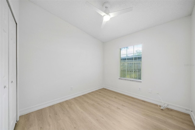 unfurnished bedroom featuring a textured ceiling, a closet, light hardwood / wood-style flooring, and ceiling fan