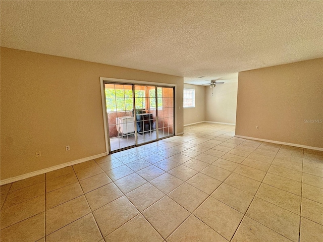 unfurnished room featuring a textured ceiling, ceiling fan, and light tile patterned floors