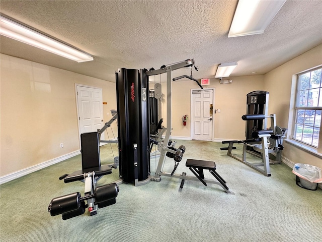 exercise room with a textured ceiling and carpet flooring