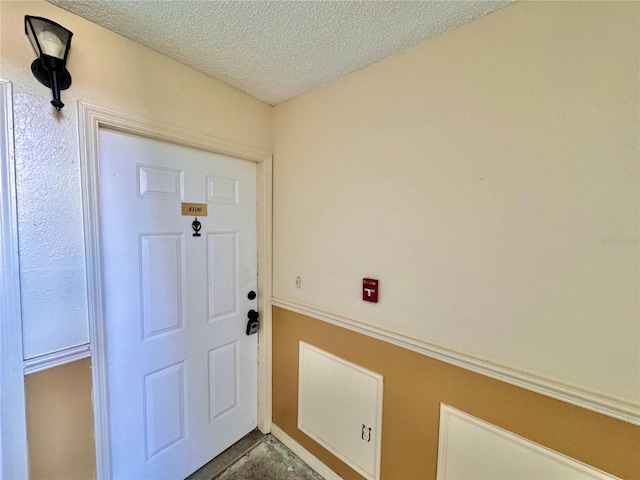 doorway to outside featuring a textured ceiling