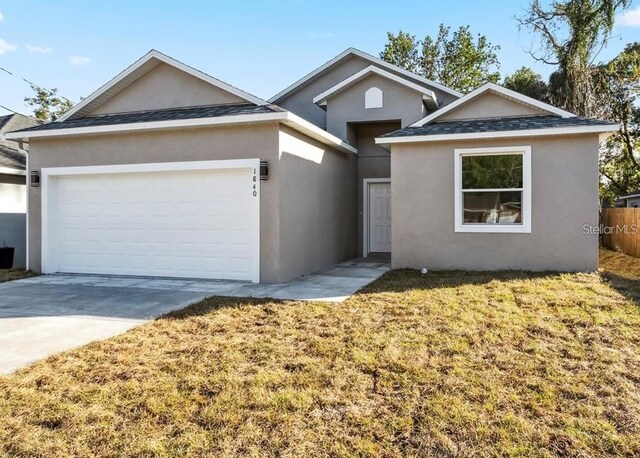 view of front of home with a garage and a front lawn