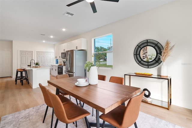 dining space with sink, ceiling fan, and light hardwood / wood-style flooring