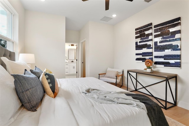 bedroom featuring ceiling fan, connected bathroom, and light hardwood / wood-style flooring