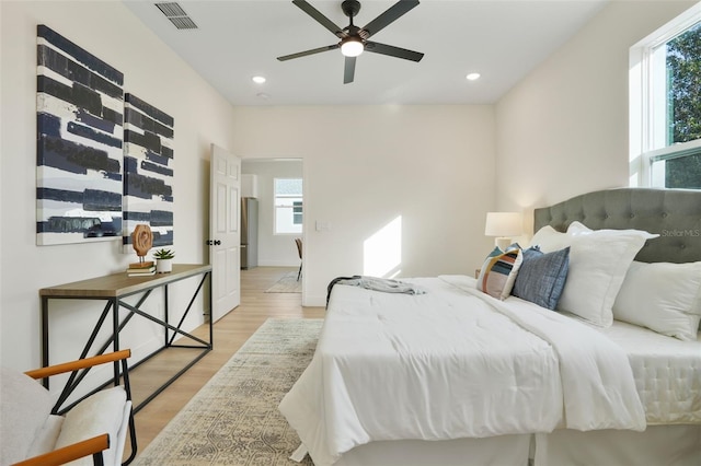 bedroom featuring light hardwood / wood-style floors, multiple windows, and ceiling fan