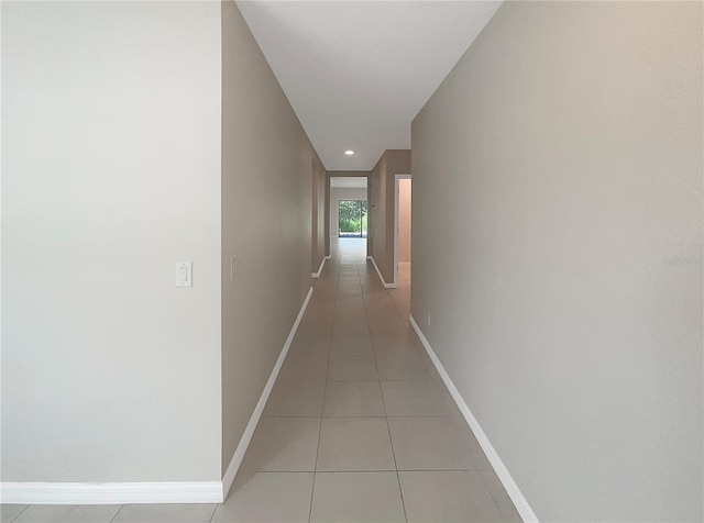 hallway featuring recessed lighting, baseboards, and light tile patterned floors