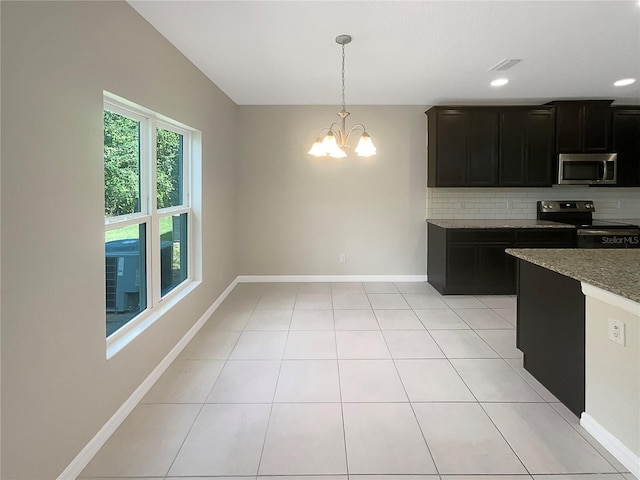 kitchen featuring light tile patterned floors, tasteful backsplash, baseboards, appliances with stainless steel finishes, and dark cabinetry